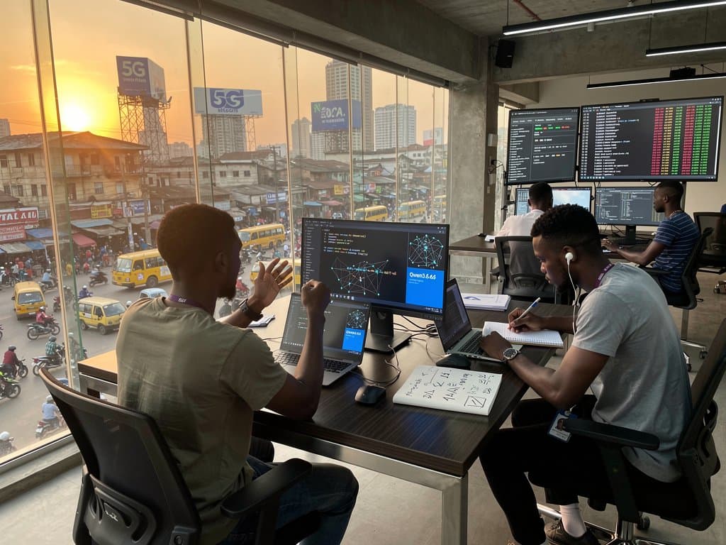 Lagos Yaba tech hub desks with laptops displaying Qwen3.6-35B-A3B AI code, solar power banks, MTN routers, and agentic flowcharts under golden light